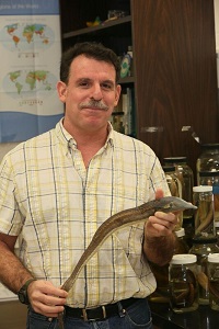 Man in plaid shirt holding a snake
